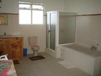 Grosses Badezimmer mit Badewann und Dusche, sogar ein Bügelbrett hat noch Platz
